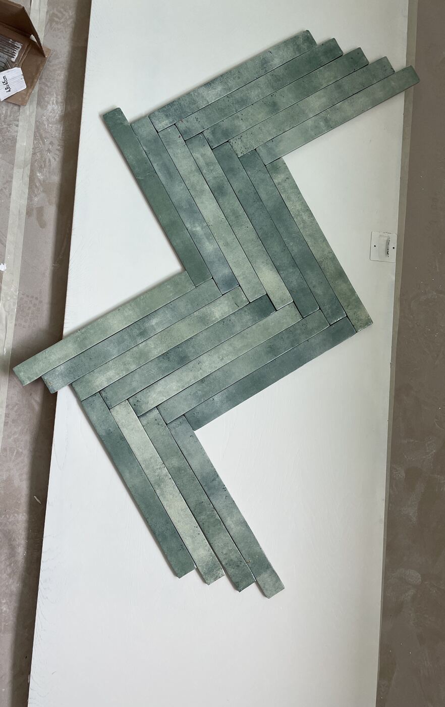Green tile laid out on a board to test the pattern during selections for a Teknik remodel