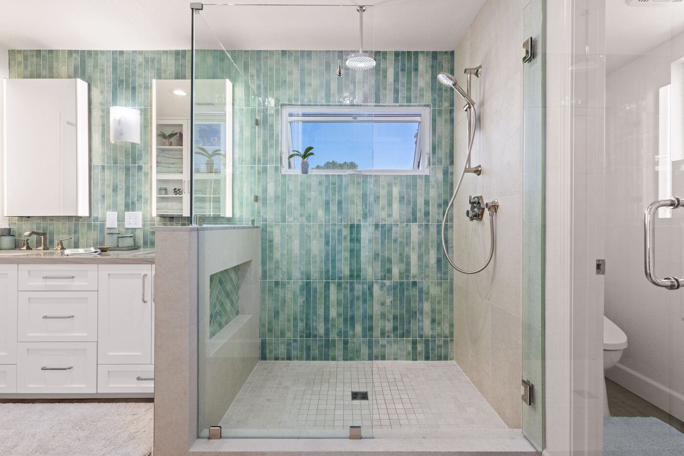 Finished shower with green glazed tile and a glass enclosure, from a Teknik remodel