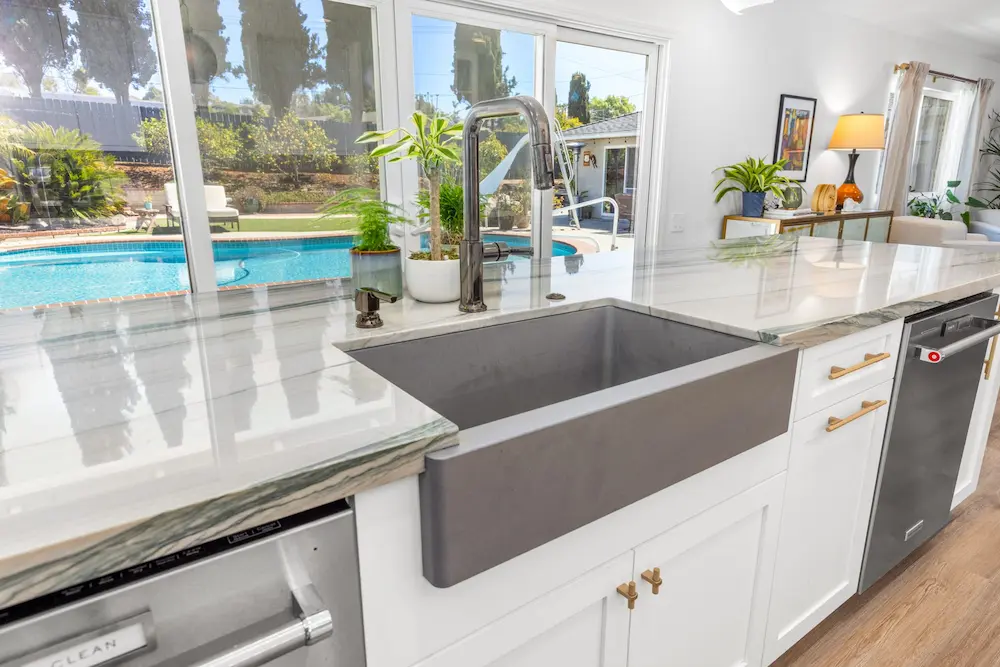 El Cajon kitchen remodel with gray farmhouse sink, marble countertop and pool view