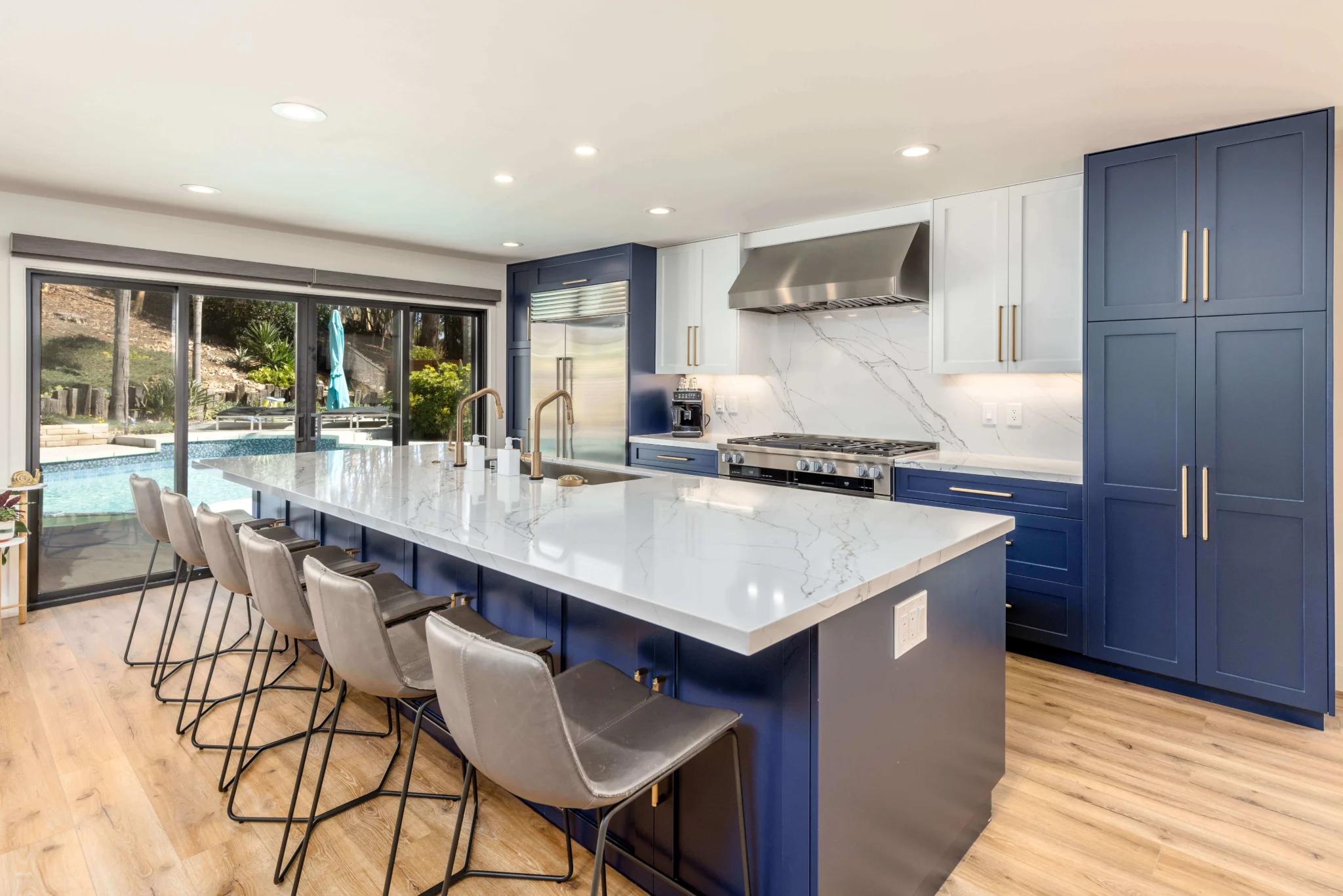 Custom kitchen remodel in San Diego with a blue island and marble countertops by Teknik Design & Remodeling