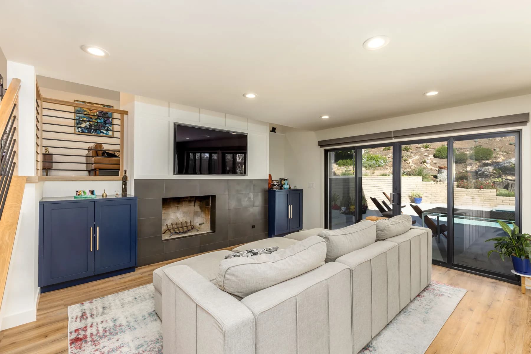 Open living room with navy built-ins and a fireplace from a Teknik whole-home remodel in San Diego