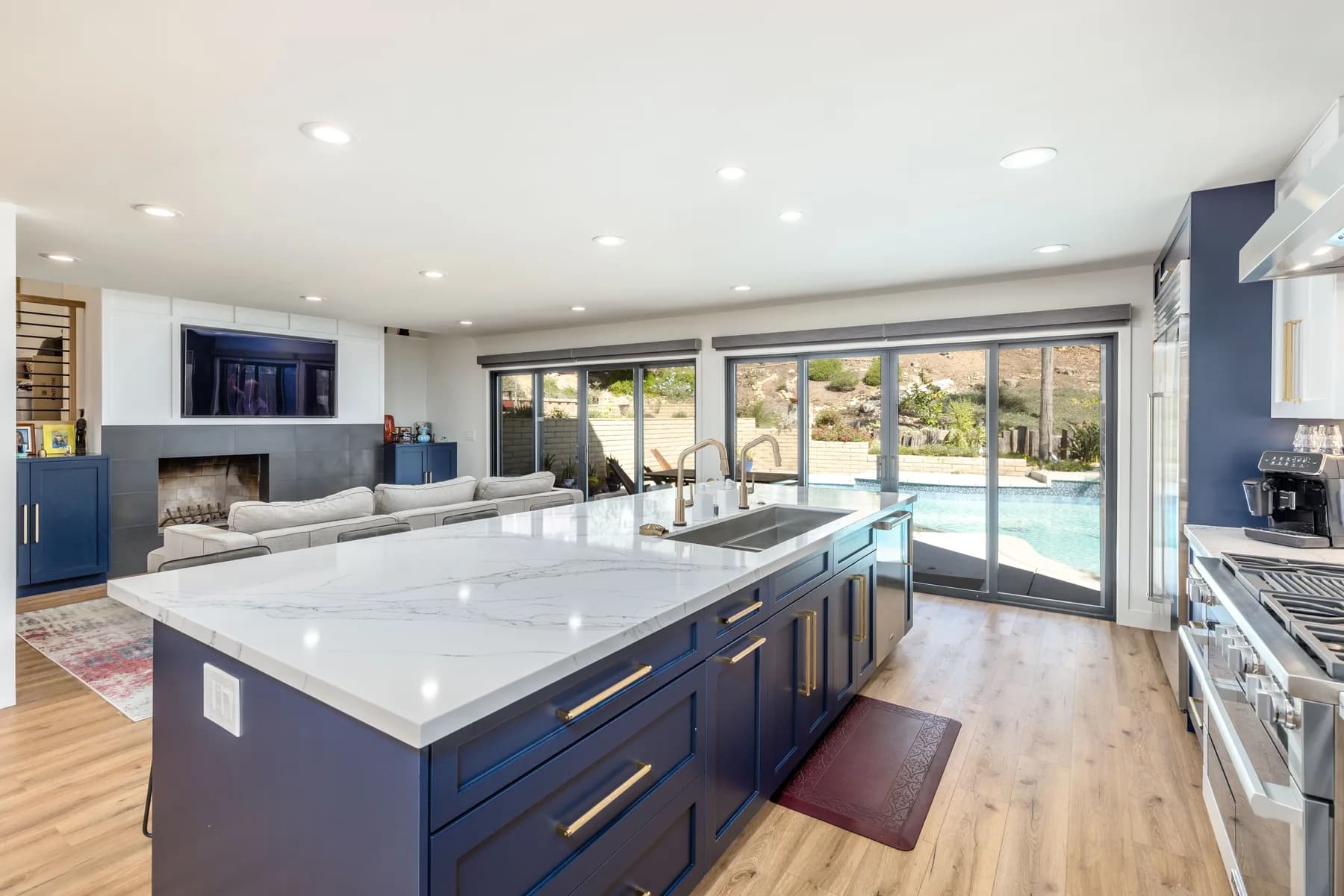 Completed open-concept kitchen and living space with hillside views by Teknik Design & Remodeling