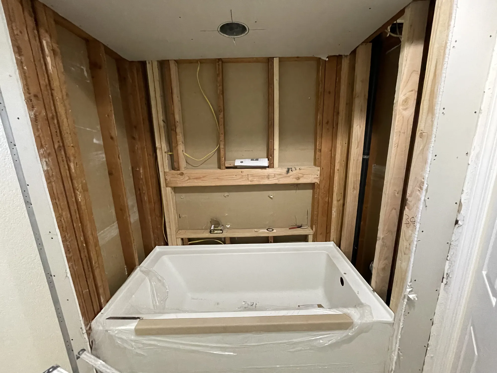 Bathroom opened to the studs with a new tub set in place