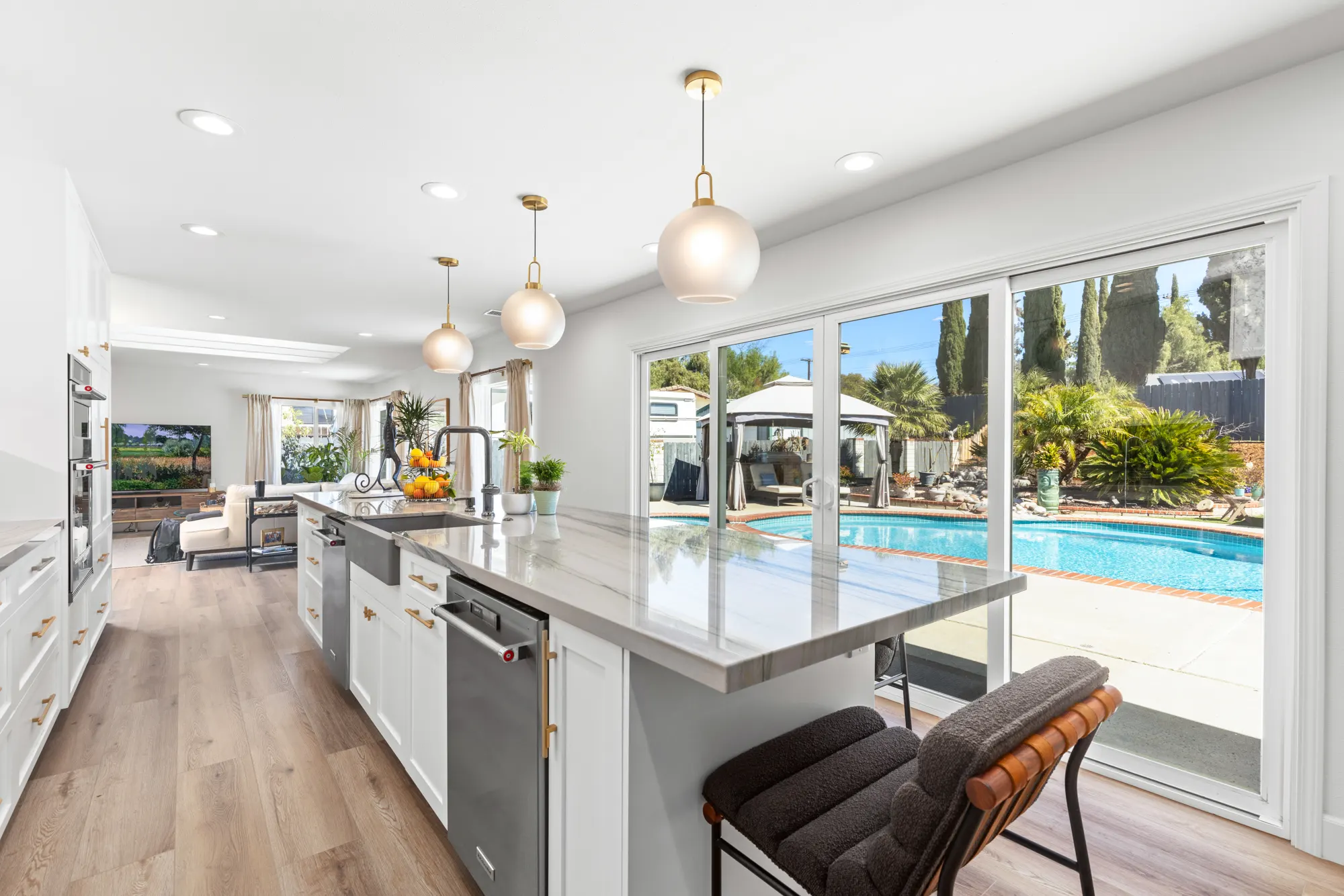 Kitchen island with pendant lights and sliding doors to the pool in El Cajon