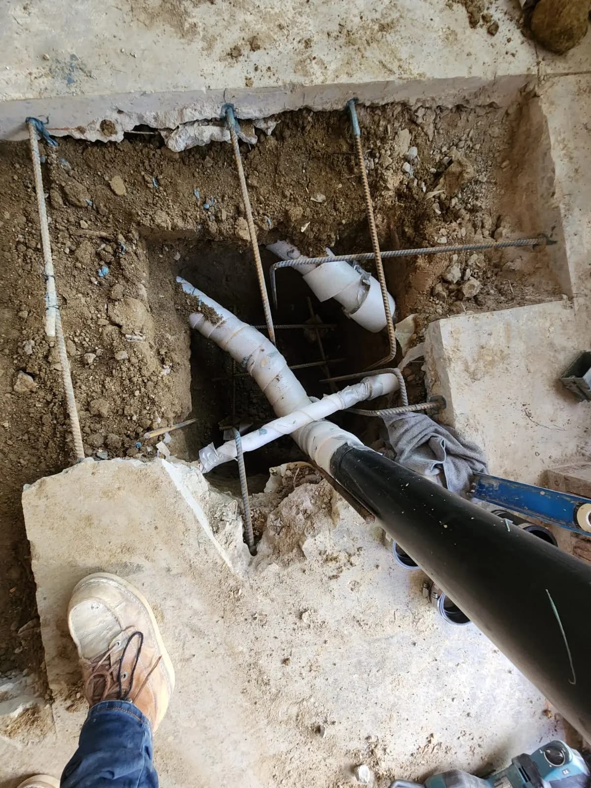 New drain lines being set in a trench under the slab