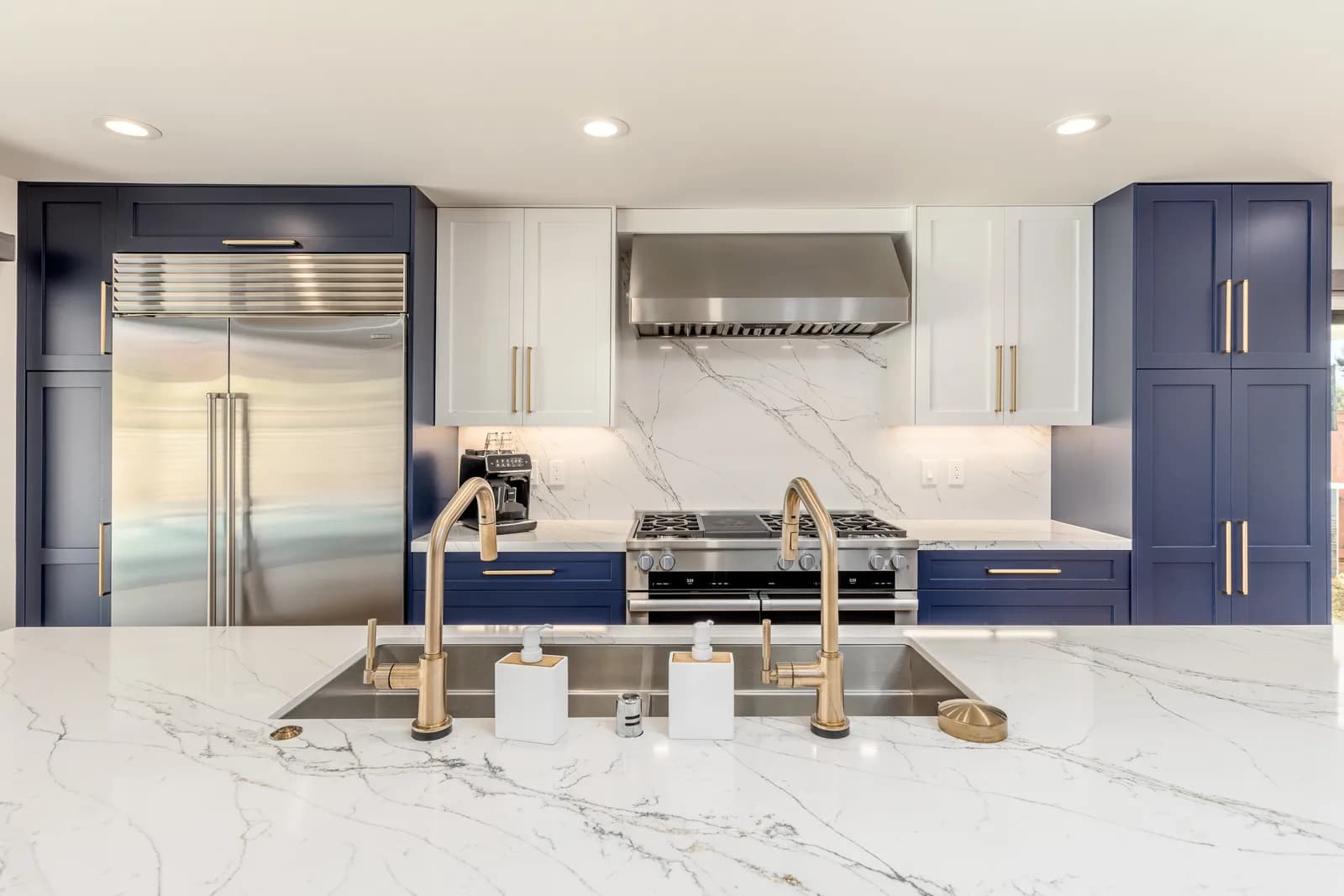Navy and marble chef kitchen with brass fixtures after the Scripps Ranch whole-home remodel