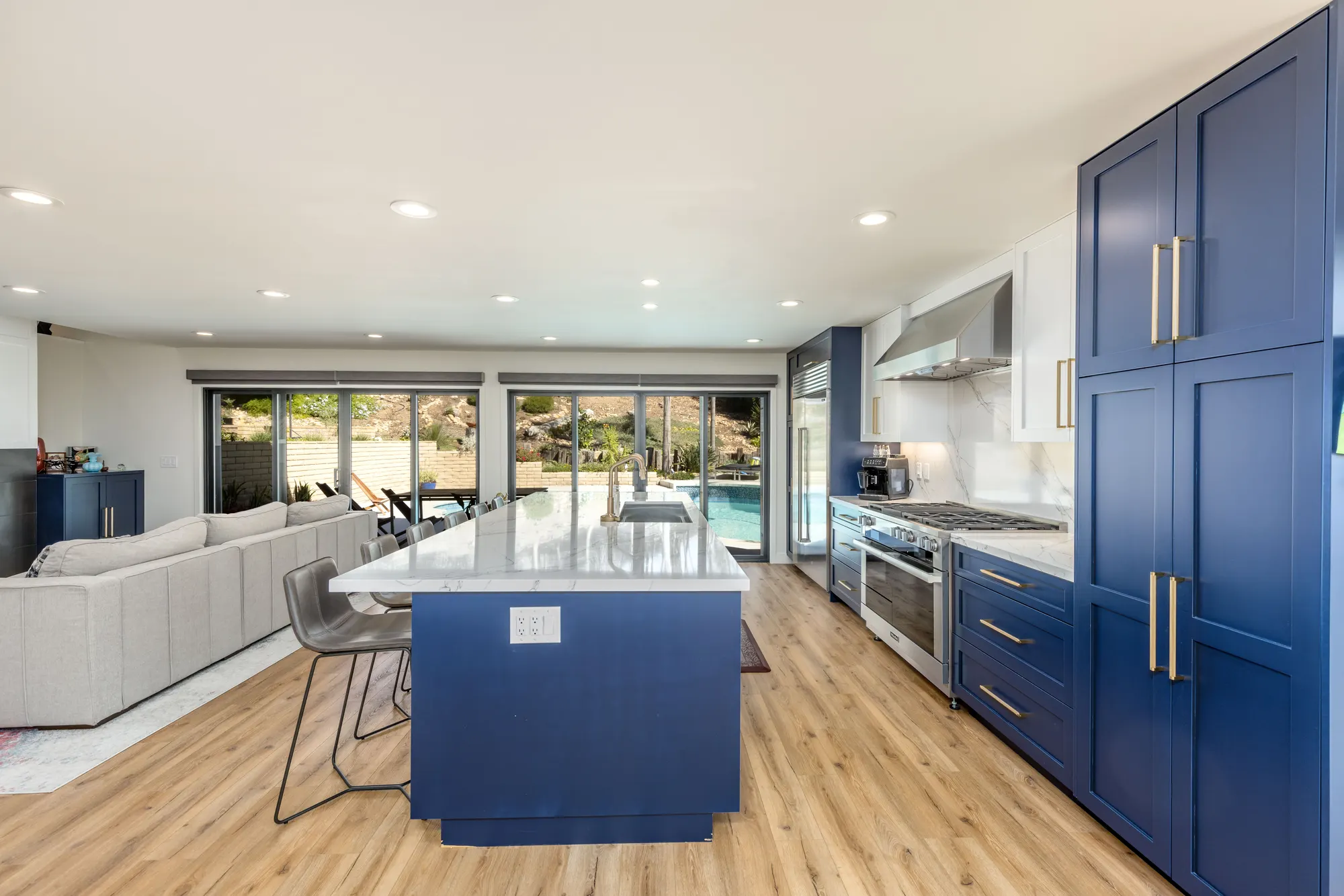 Navy and white kitchen open to the family room and pool in Scripps Ranch
