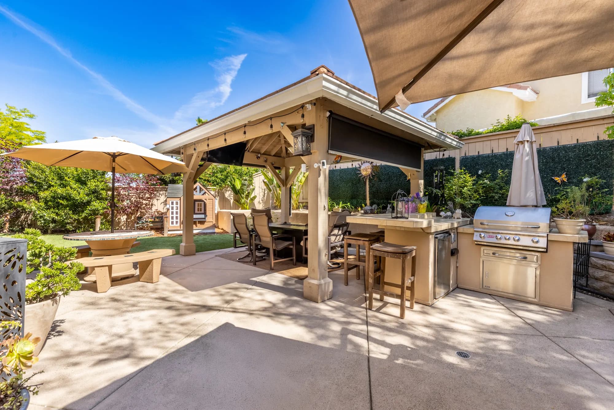 Outdoor kitchen with a built-in grill beside a gazebo in a Tierrasanta home remodeled by Teknik